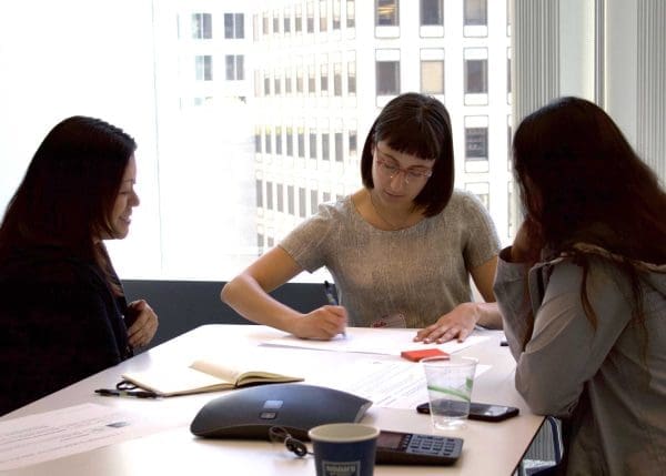 Three Co-Workers Writing Out Ideas